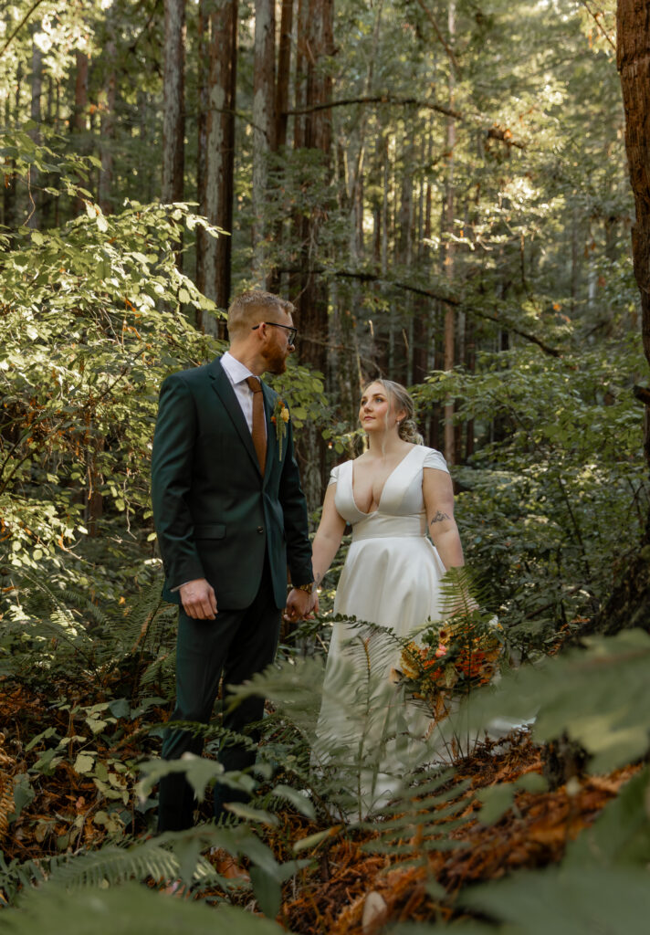 Couple walking through redwood forest in Big Sur during elopement