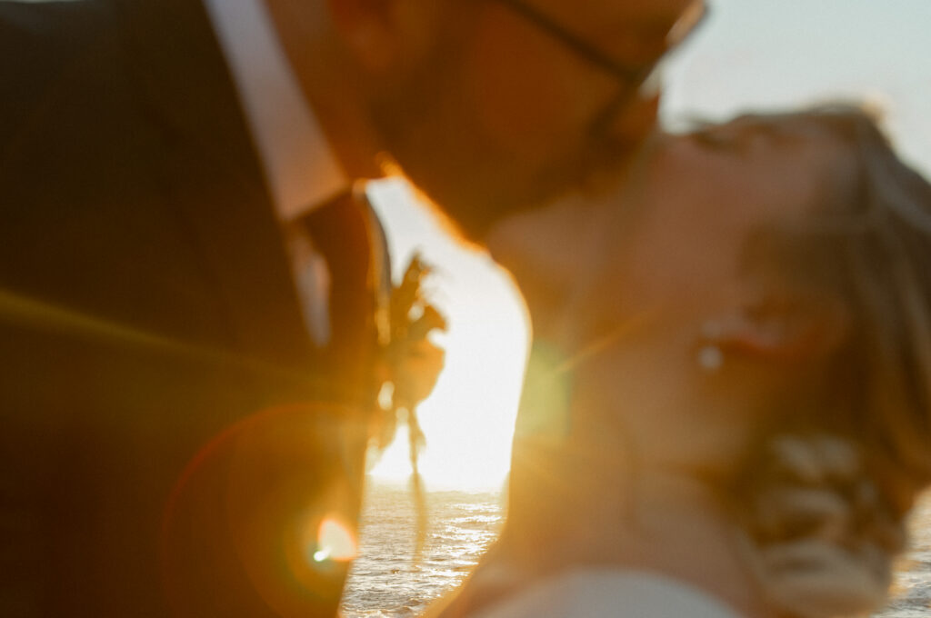 Bride and groom kissing at sunset during Big Sur elopement