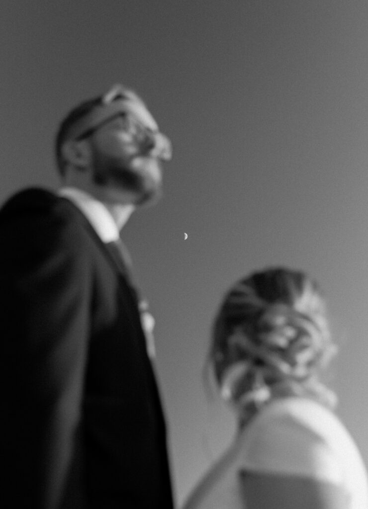 Couple looking at the moon on coastal cliffs during Big Sur elopement