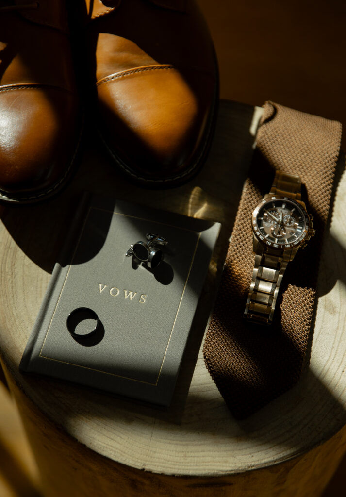 Groom details including shoes, watch, and vow book before Big Sur elopement
