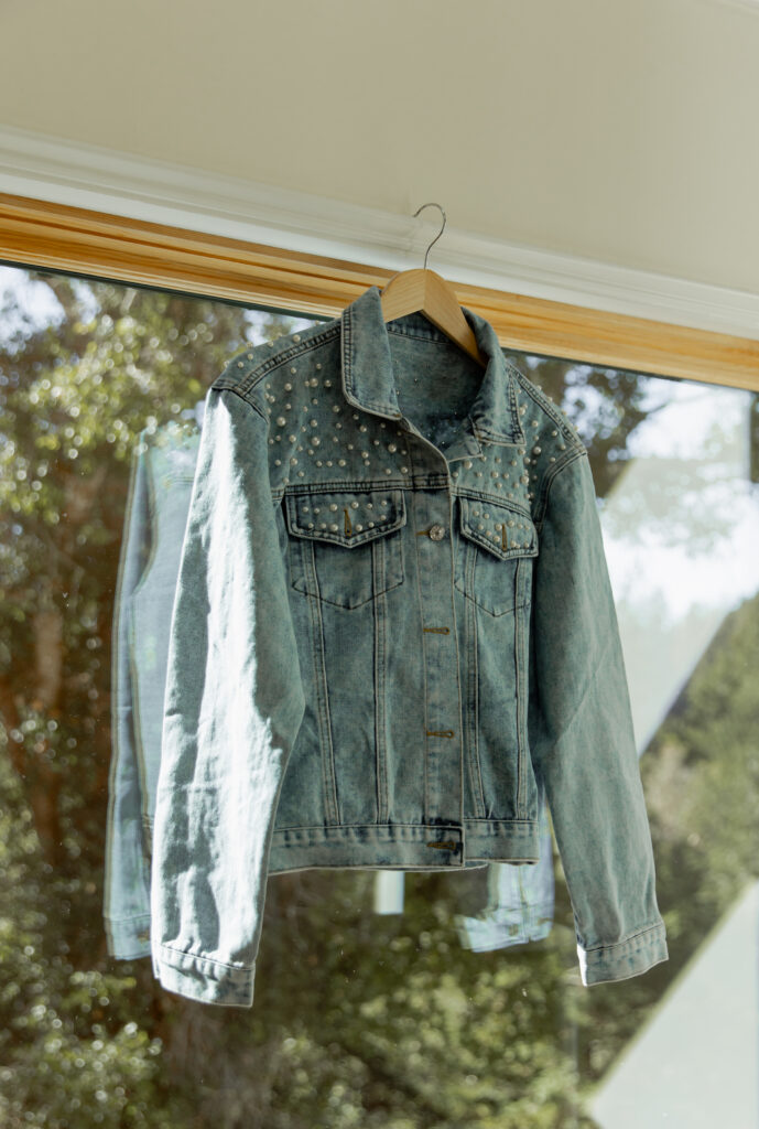 Denim jacket hanging in window light before Big Sur elopement
