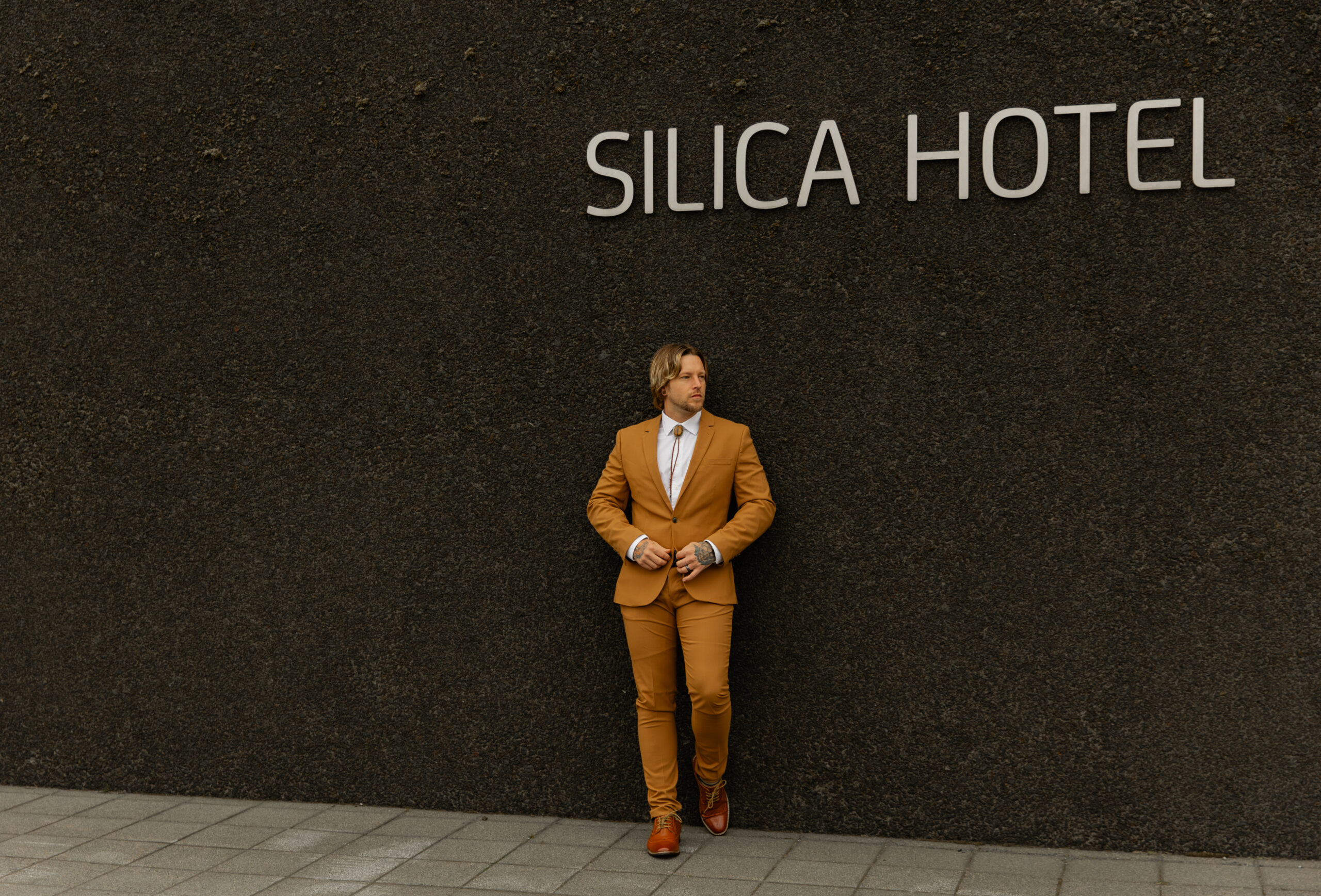 Groom portrait outside Silica Hotel in Iceland before intimate vow renewal