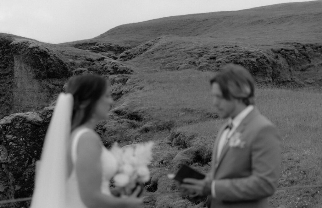 Artistic black and white photo of couple exchanging vows at Fjaðrárgljúfur Canyon in Iceland