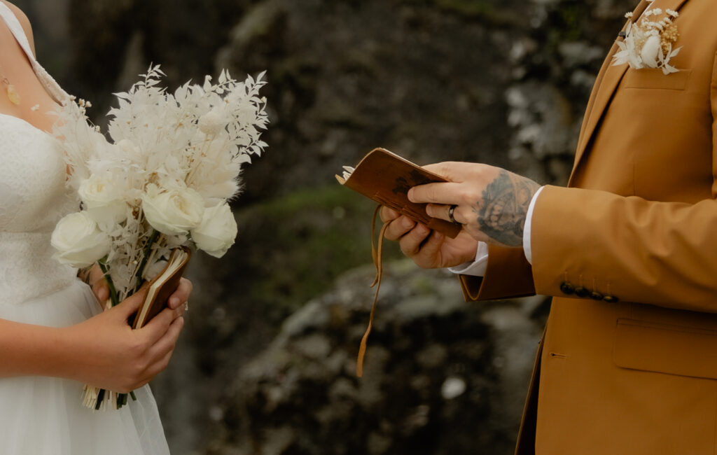 Bride and groom reading vows during private vow renewal in Iceland