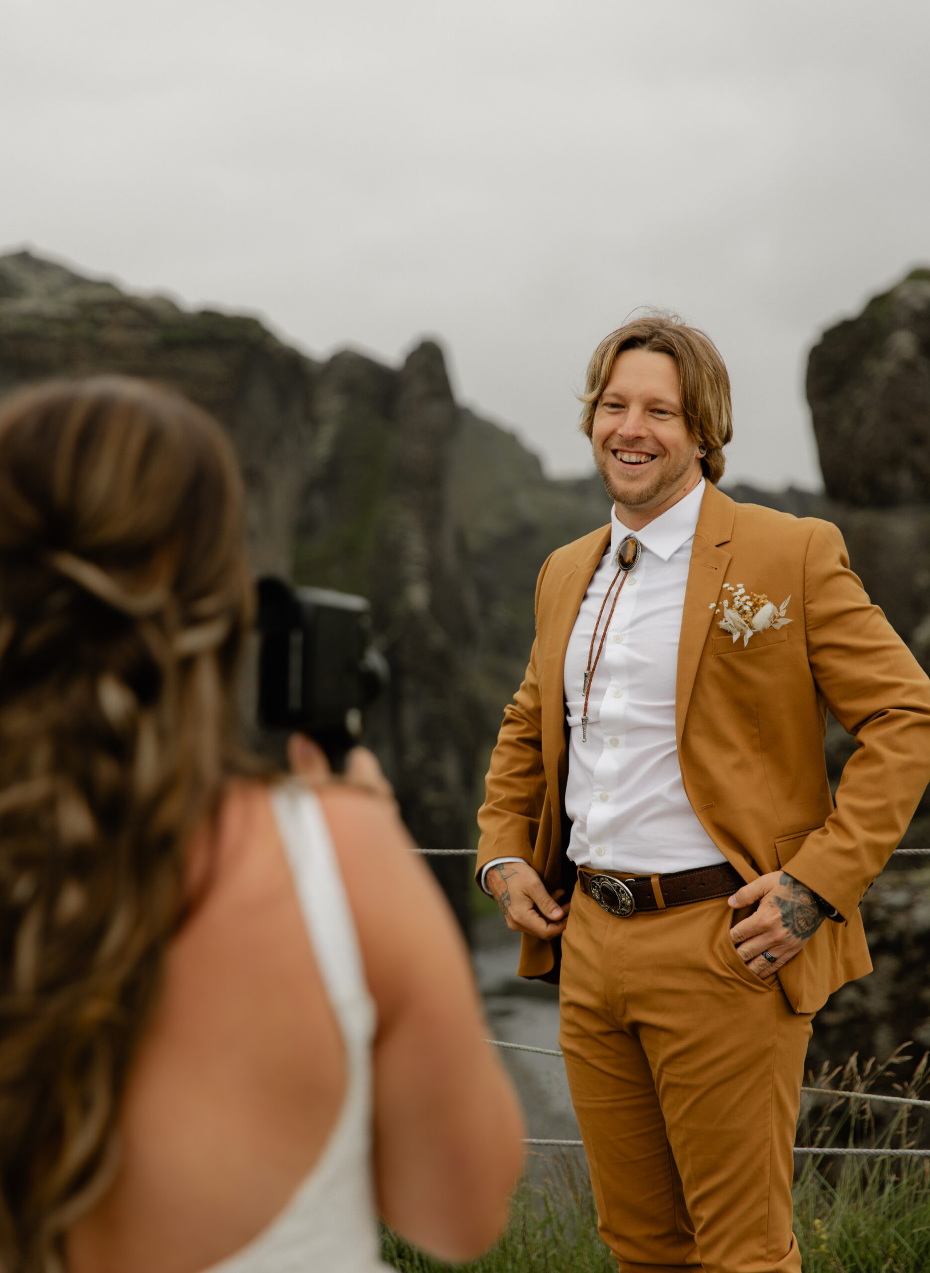 Bride photographing groom during portraits at Fjaðrárgljúfur Canyon in Iceland