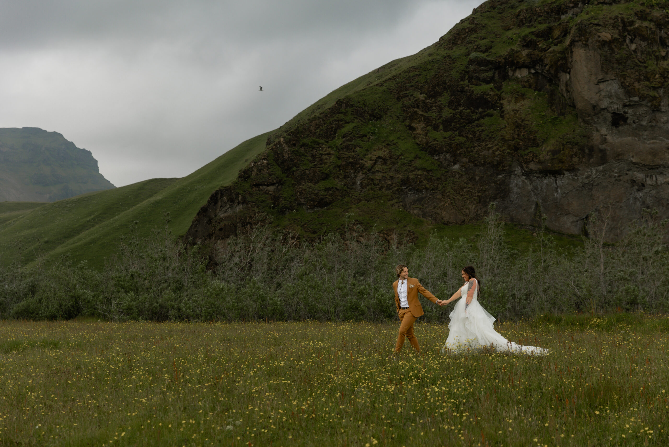 Wide portrait of couple walking through Iceland landscape during intimate elopement
