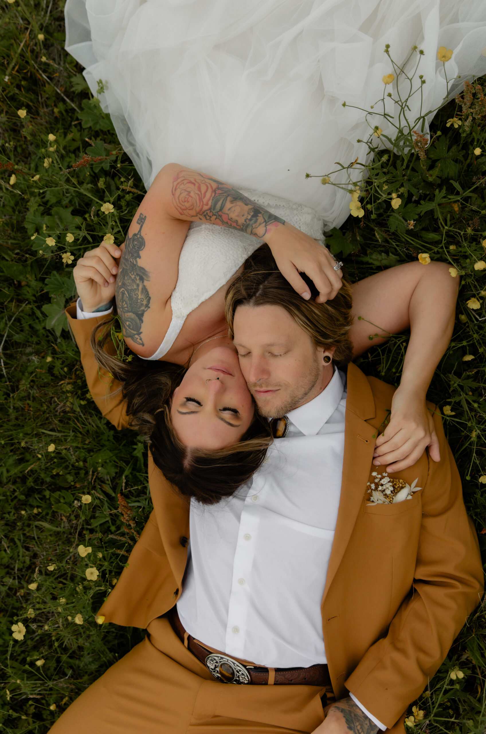 Overhead portrait of bride and groom lying in wildflowers during Iceland elopement